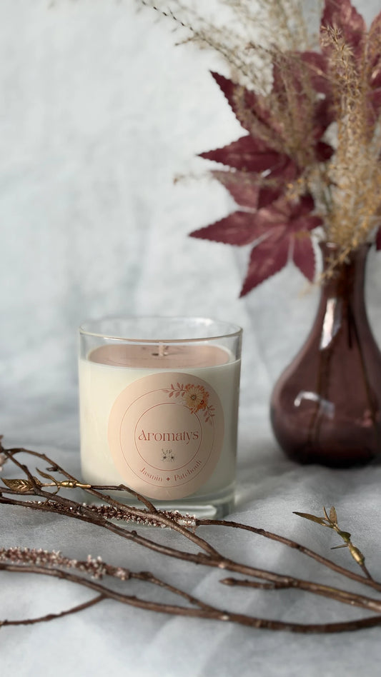 Bougie parfumée Jasmin Patchouli Aromatys en pot de verre, avec branches et fleurs séchées.