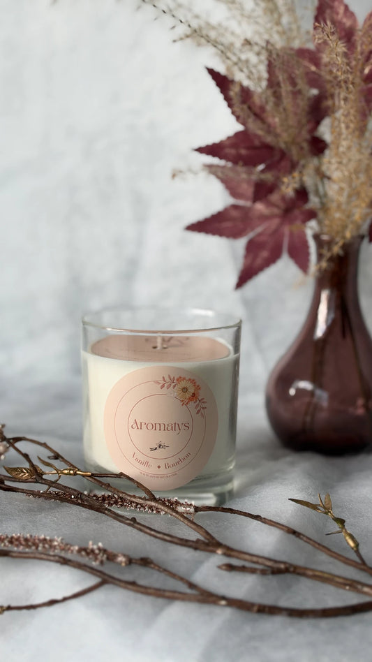Bougie parfumée Vanille Bourbon Aromatys en pot de verre, avec branches et fleurs séchées.
