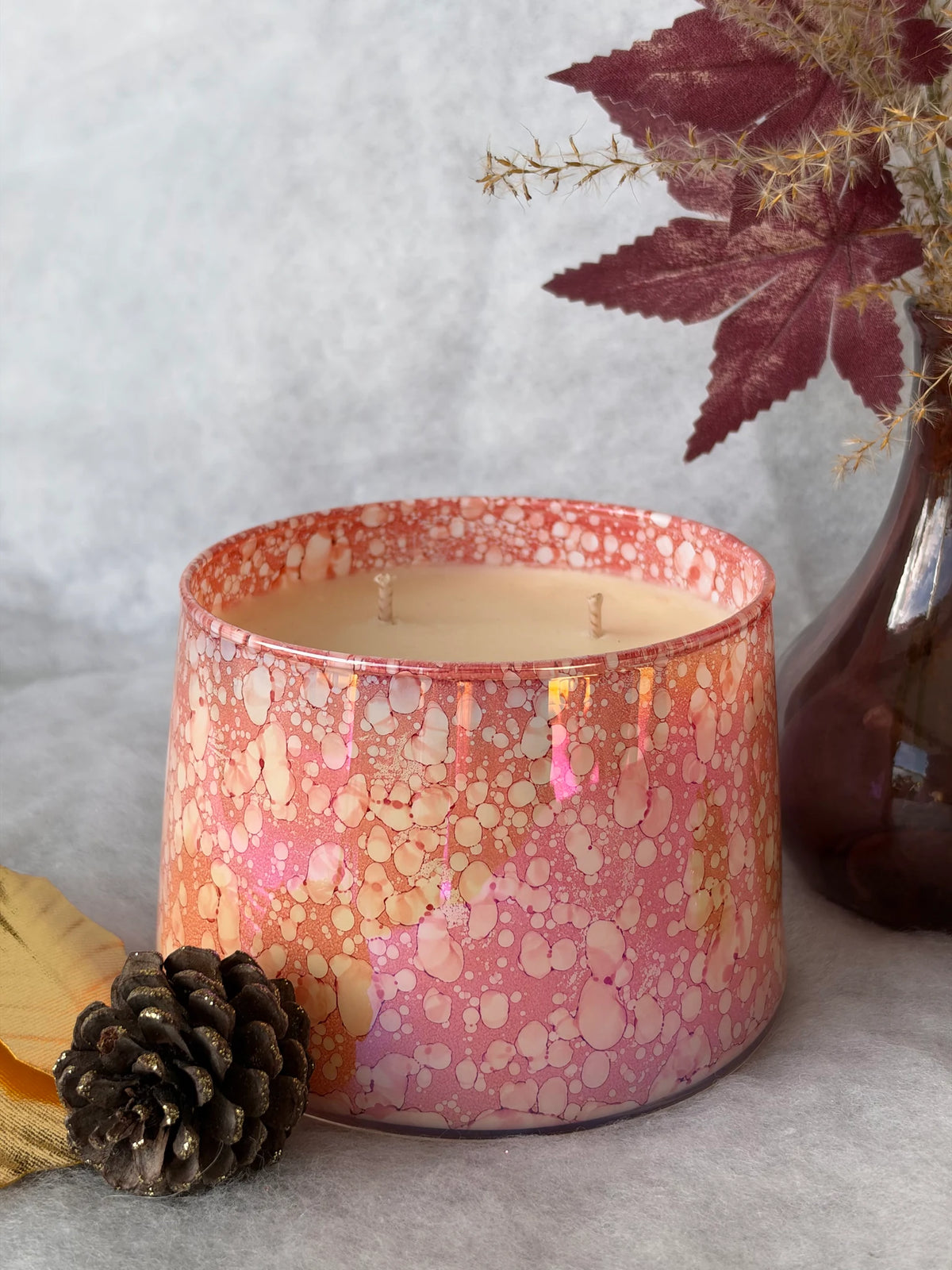 Bougie Prestige Aromatys dans son pot en verre rouge irisé.